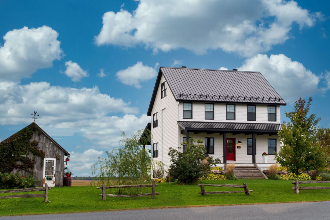 Maison de ville au milieu de terrain avec des clôtures en bois